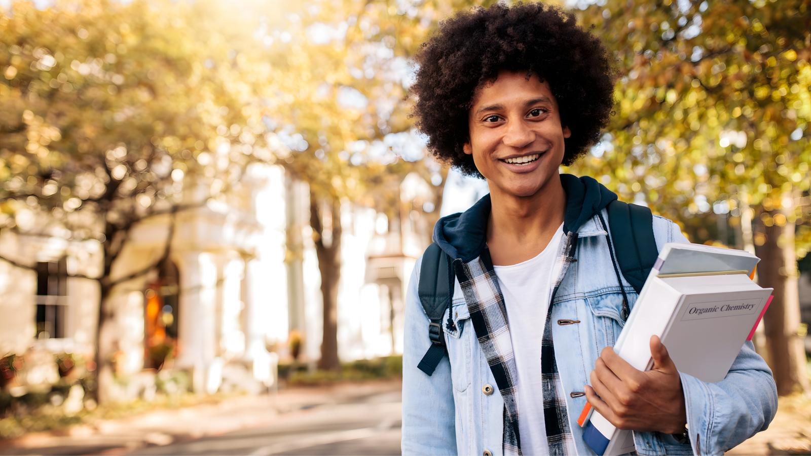 Smiling Caribbean boy holding a book, ready to learn